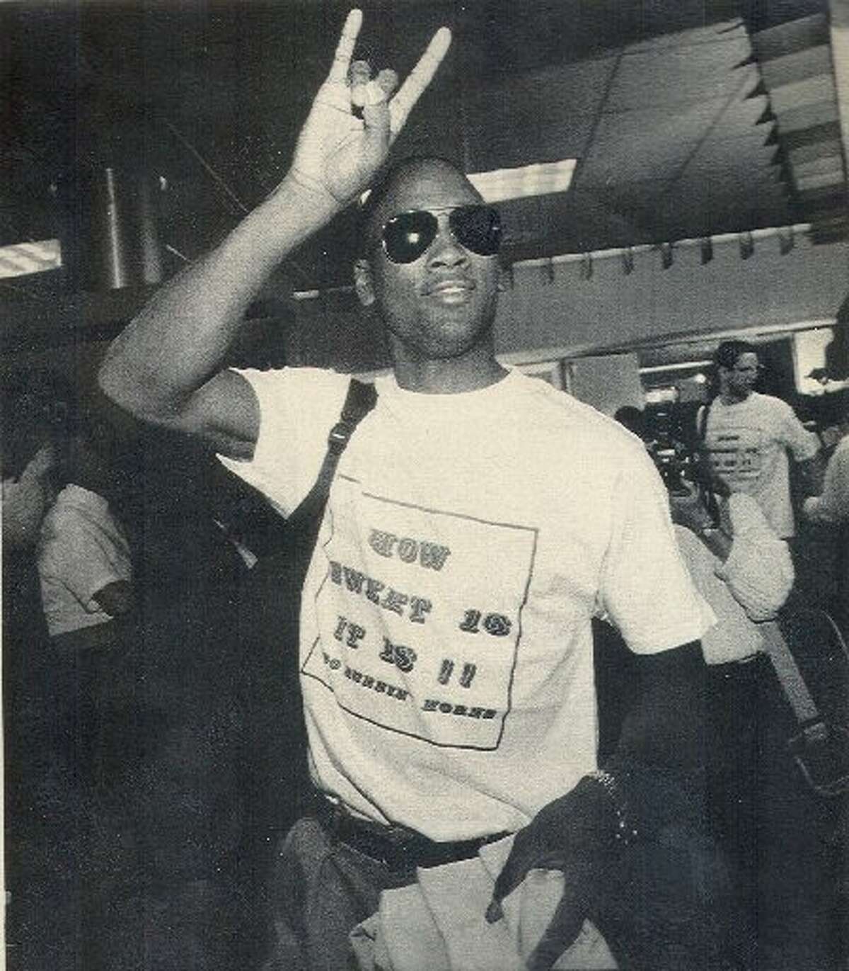 Texas' Lance Blanks flashes the 'Hook 'em Horns' salute as the Longhorns arrived home after securing a berth in the 1990 Sweet 16.