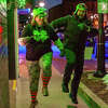 Midland residents Renee (left) and Zach Raushi skip during the Shamrock Sip and Strut on March 18, 2023 in Downtown Midland.