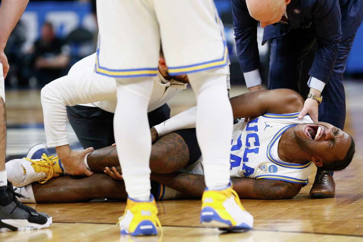 UCLA Bruins guard David Singleton (34) is attended after an injury during the second half of a second-round college basketball game against the Northwestern Wildcats in the men's NCAA Tournament, Saturday, March 18, 2023, in Sacramento. The UCLA Bruins won 68-63.