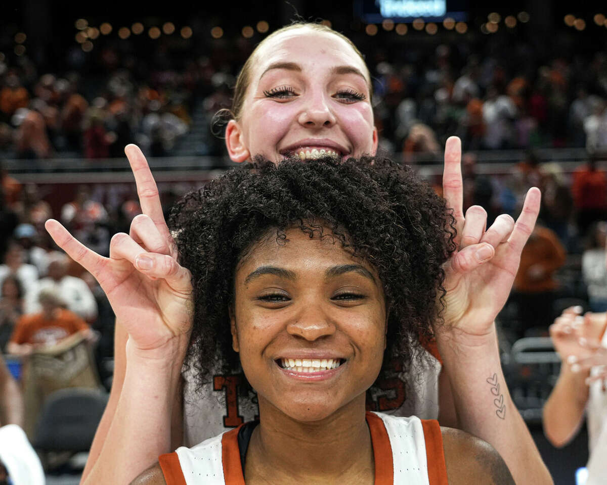 Texas forward Taylor Jones signals hook 'em horns next to Rori Harmon's head after the team's win over East Carolina in a first-round college basketball game in the women's NCAA Tournament on Saturday March 18, 2023, in Austin, Texas. (Aaron E. Martinez/Austin American-Statesman via AP)