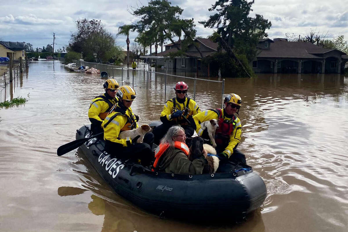 周六，救援人员通过图拉雷县被洪水淹没的地区运送居民。