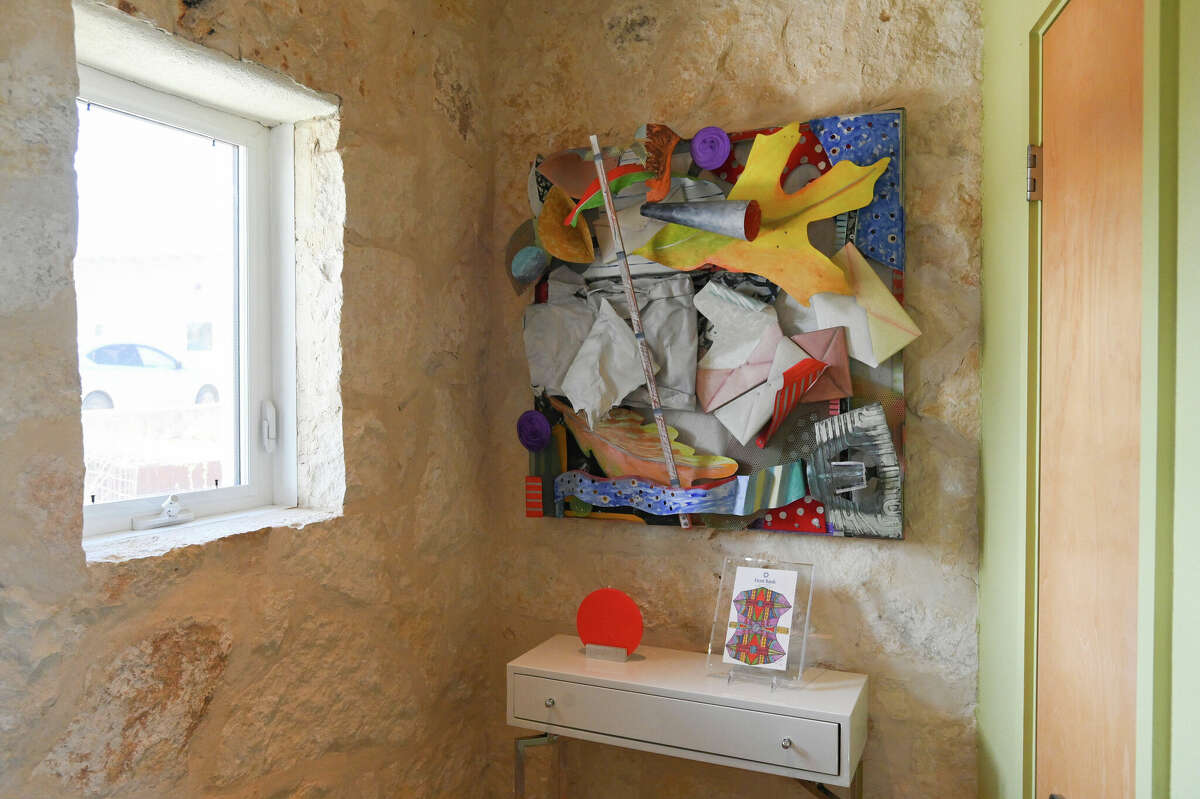 One of the couple's pieces of contemporary art is displayed in the front foyer against some exposed limestone walls.