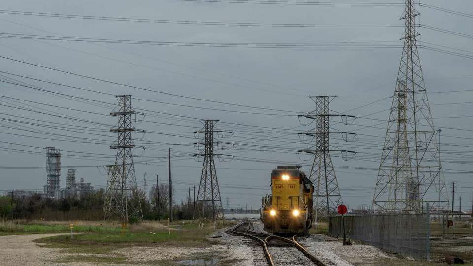 HOUSTON, TEXAS - DECEMBER 22: A train sits on standby while passing through transmission towers near the CenterPoint Energy facility on December 22, 2022 in Houston, Texas. Gov. Greg Abbott and state officials have begun warning residents to prepare for subfreezing temperatures as a cold front looms over the state of Texas. ERCOT (The Electric Reliability Council of Texas) and the Public Utility Council have assured residents that the power grid will remain stable amidst freezing conditions.