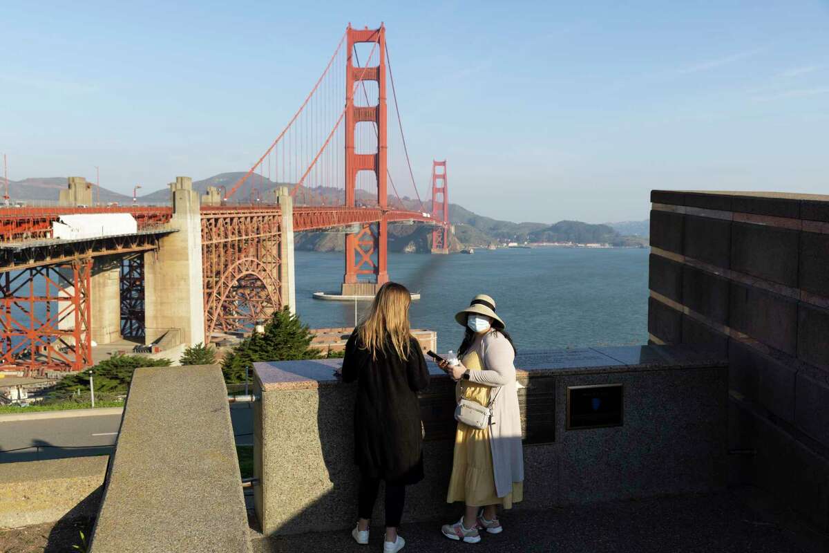 Katie Perkins (left) and Rayo Velasco visit the Golden Gate Bridge while in town for a work trip in San Francisco in 2022. The city's tourism numbers shot up during 2022.