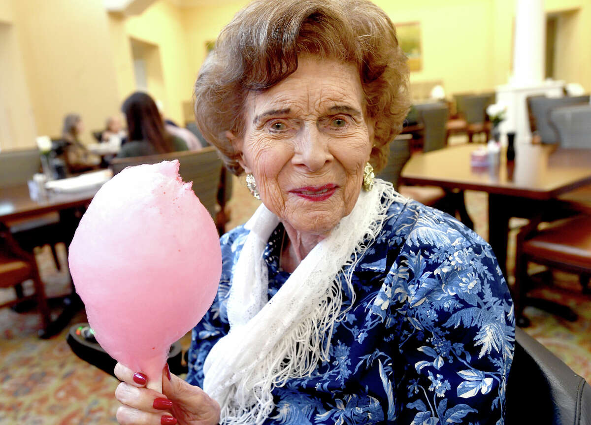 Alice Keith, 105 years old, poses with her bourbon chocolate cherry cotton candy treat during a BBQ and Bourbon social event at Calder Woods in Beaumont Tuesday. Photo made Tuesday, March 21, 2023 Kim Brent/Beaumont Enterprise