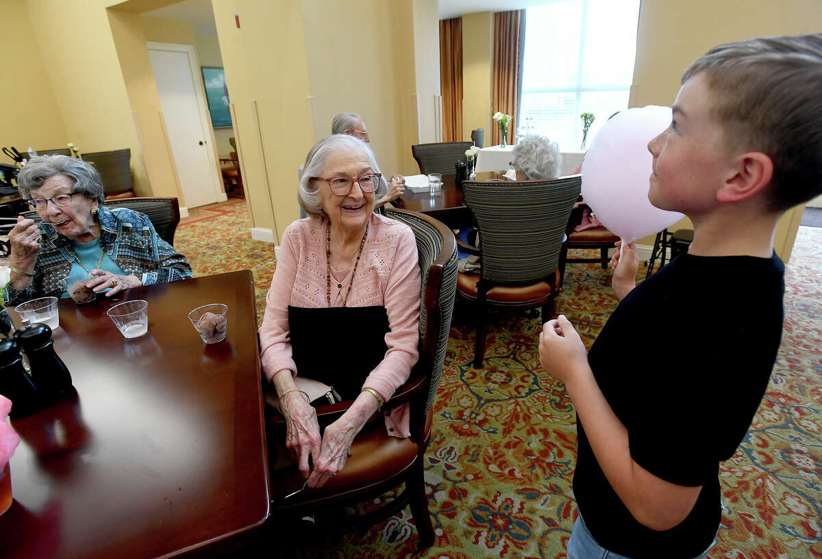 JoAnn Cannon talks with Charlie Avondet, whose mother Chelsie Avondet is the director of marketing at Calder Woods, during a BBQ and Bourbon social event at Calder Woods in Beaumont Tuesday. Photo made Tuesday, March 21, 2023 Kim Brent/Beaumont Enterprise