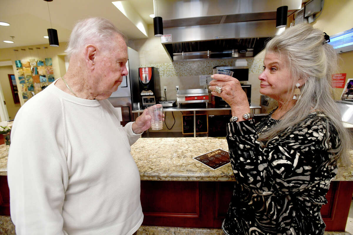 Polly Ashworth offers a toast as she and father Howard Cobb sample bourbons during a BBQ and Bourbon social event at Calder Woods in Beaumont Tuesday. Photo made Tuesday, March 21, 2023 Kim Brent/Beaumont Enterprise