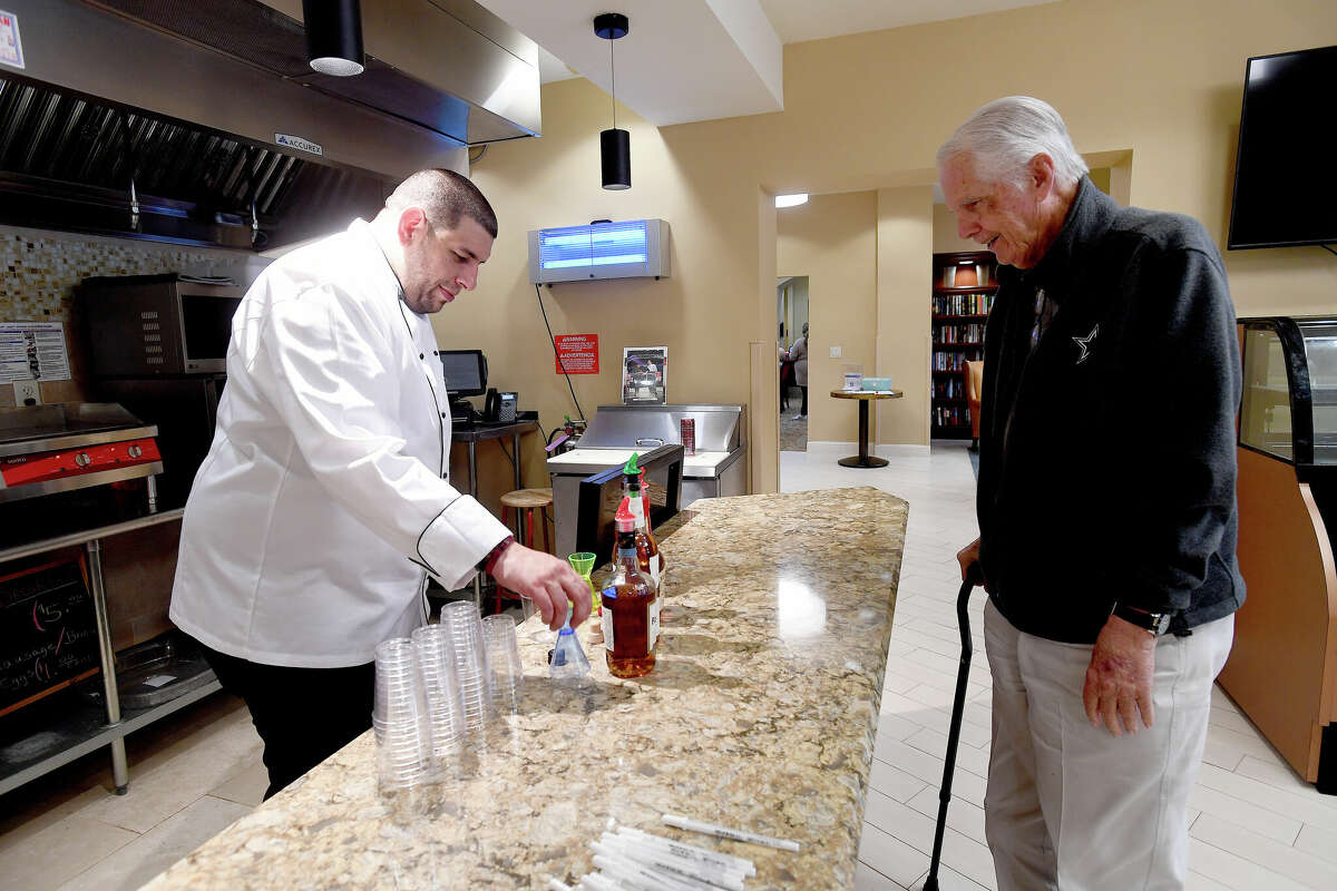 Jim Cornelius awaits the pour of a bourbon sampling from Culinary Director Andre Glassey during a BBQ and Bourbon social event at Calder Woods in Beaumont Tuesday. Photo made Tuesday, March 21, 2023 Kim Brent/Beaumont Enterprise