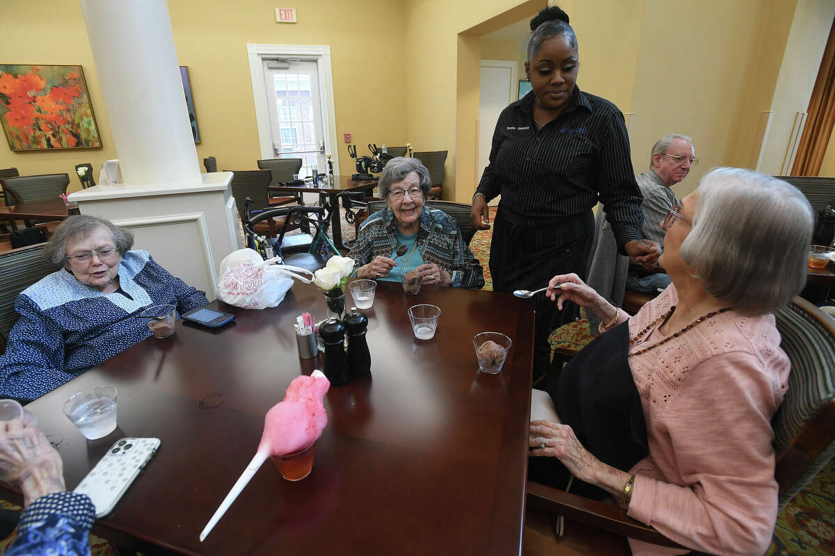 Residents talk with staff as they enjoy a BBQ and Bourbon social event at Calder Woods in Beaumont Tuesday. Photo made Tuesday, March 21, 2023 Kim Brent/Beaumont Enterprise