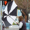An umbrella is flipped inside out by high winds during a rainstorm in Alameda, California on March 21, 2023.