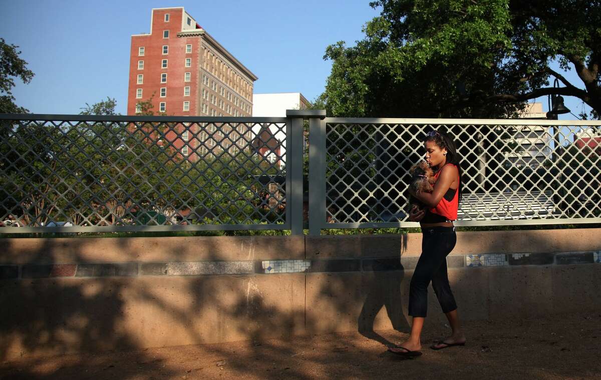 Downtown resident Kelsye Freeman kisses her dog Sueki while at the dog park in the renovated Market Square. There are between 3,500 and 4,000 people living in downtown now.