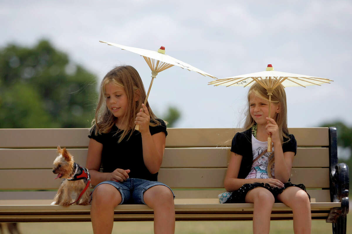 Camila Alvares, 9, left, of Katy, sits on a park bench with her dog, Cloe, a Yorkshire Terrier and friend Juliana Wilson, 8, at Millie Bush Dog Park in George Bush Park Sunday, June 10, 2012, in Houston.