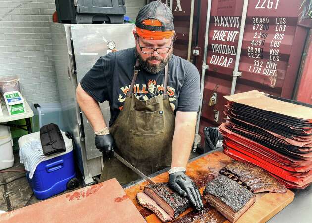 Willow Villarreal cutting brisket at Willow's Texas BBQ pop-up at Two Headed Dog bar