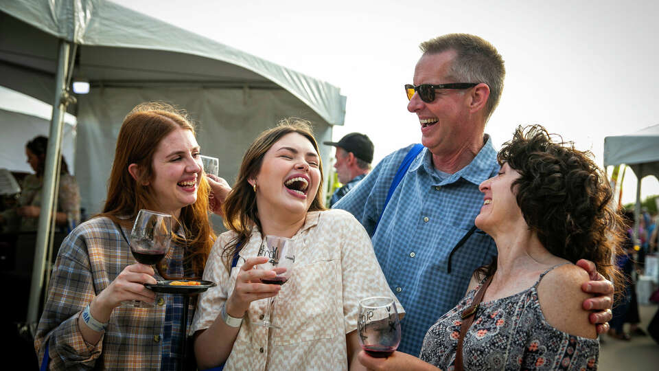 Visitors to the 2022 Sip N Stroll enjoy a wine tasting.