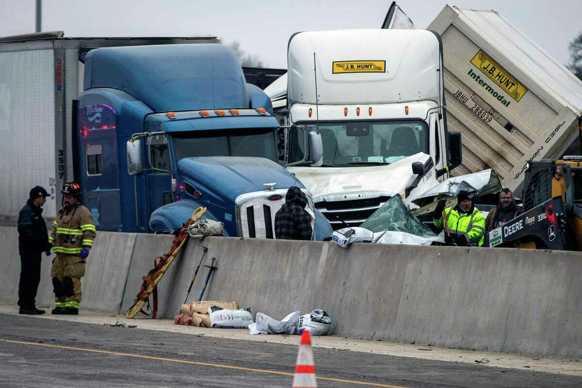 FILE - Emergency personnel cleanup after a massive pileup on Interstate 35 on Feb. 11, 2021, near downtown Fort Worth, Texas. The company responsible for the Texas interstate where 130 vehicles crashed in icy conditions two years ago, killing six, failed to address the deteriorating road conditions, federal officials said Thursday, March 23, 2023. (Yffy Yossifor/Star-Telegram via AP, File)