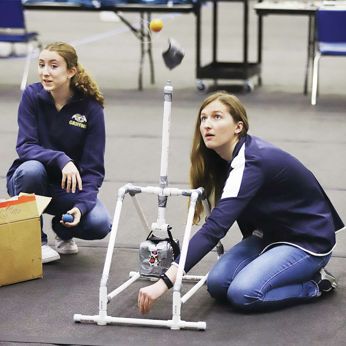 Father McGivney Catholic High School student Alyssa Tevhaar, right, fires off a practice launch Friday in the 16th Annual Trebuchet Competition held in the Riverbend Arena at Lewis and Clark Community College in Godfrey.