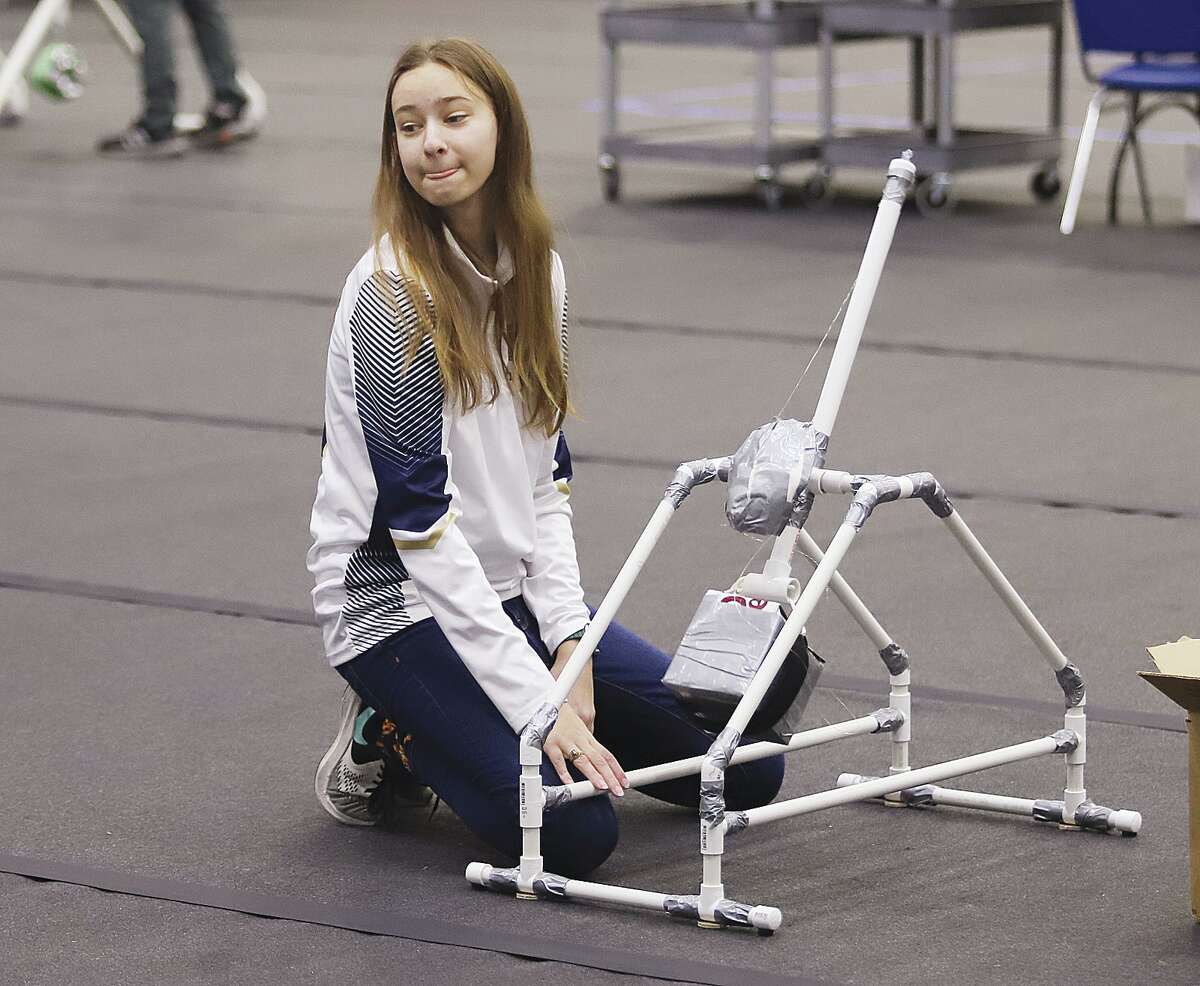 Mindy Smith, a student of Father McGivney Catholic High School in Glen Carbon, watches where her trebuchet ball lands during warm ups Friday at Lewis and Clark Community College in Godfrey.