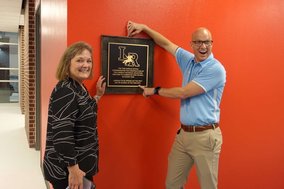 Lumberton ISD Career and Technical Education Director Vicki Mouton, left, and Superintendent Tony Tipton, right, after the time capsule is placed into the wall of the high school's new Career and Technical Education building. Photo taken March 23, 2023. Photo by Olivia Malick/ The Enterprise