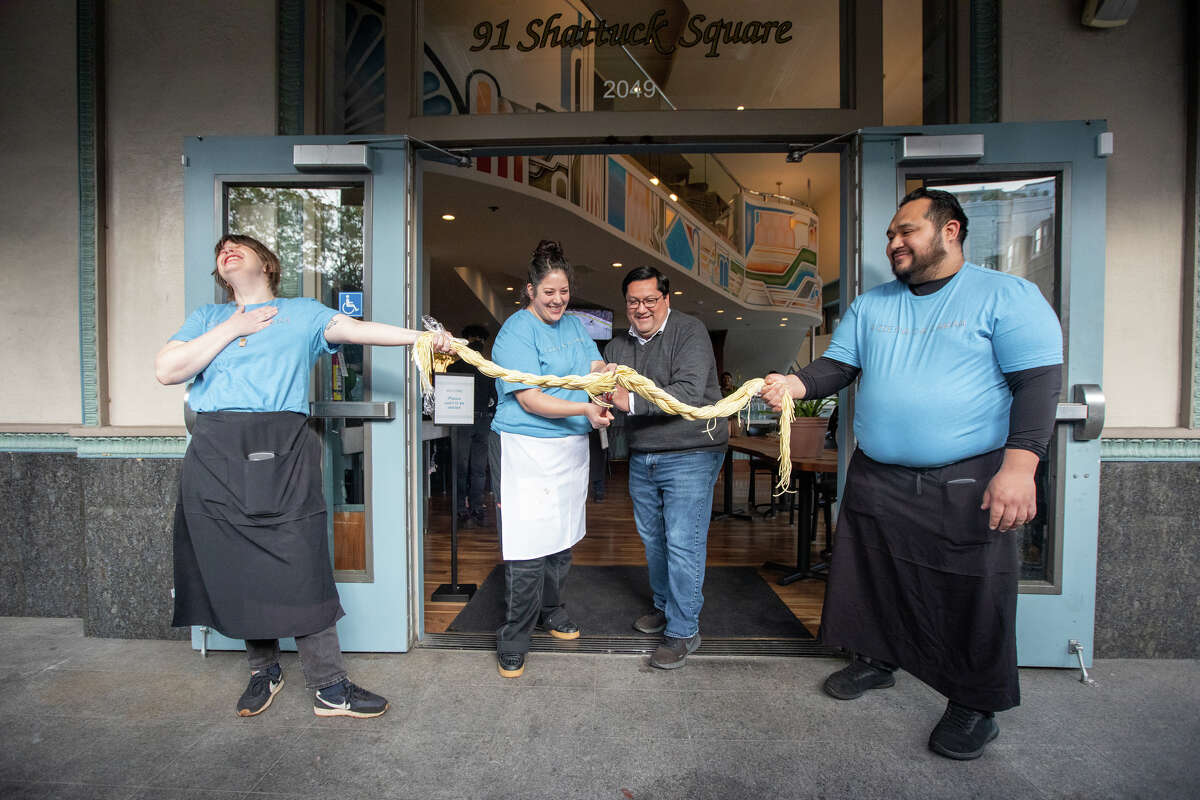 Pizzeria da Laura owner Laura Meyer, second from left, and Berkeley Mayor Jesse Arreguin cut a ceremonial rope of pasta to signify the opening of the pizzeria in Berkeley, Calif., on March 23, 2023.