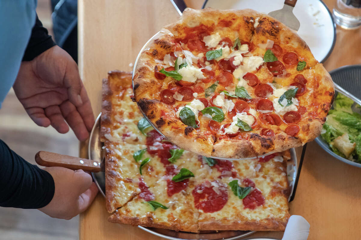 Top, the New York-style pepperoni pizza, and below, the Marge pizza, grandma-style, with mozzarella, sauce, basil and grated Parmigiano-Reggiano, are served at Pizzeria da Laura in Berkeley, Calif., on March 23, 2023.