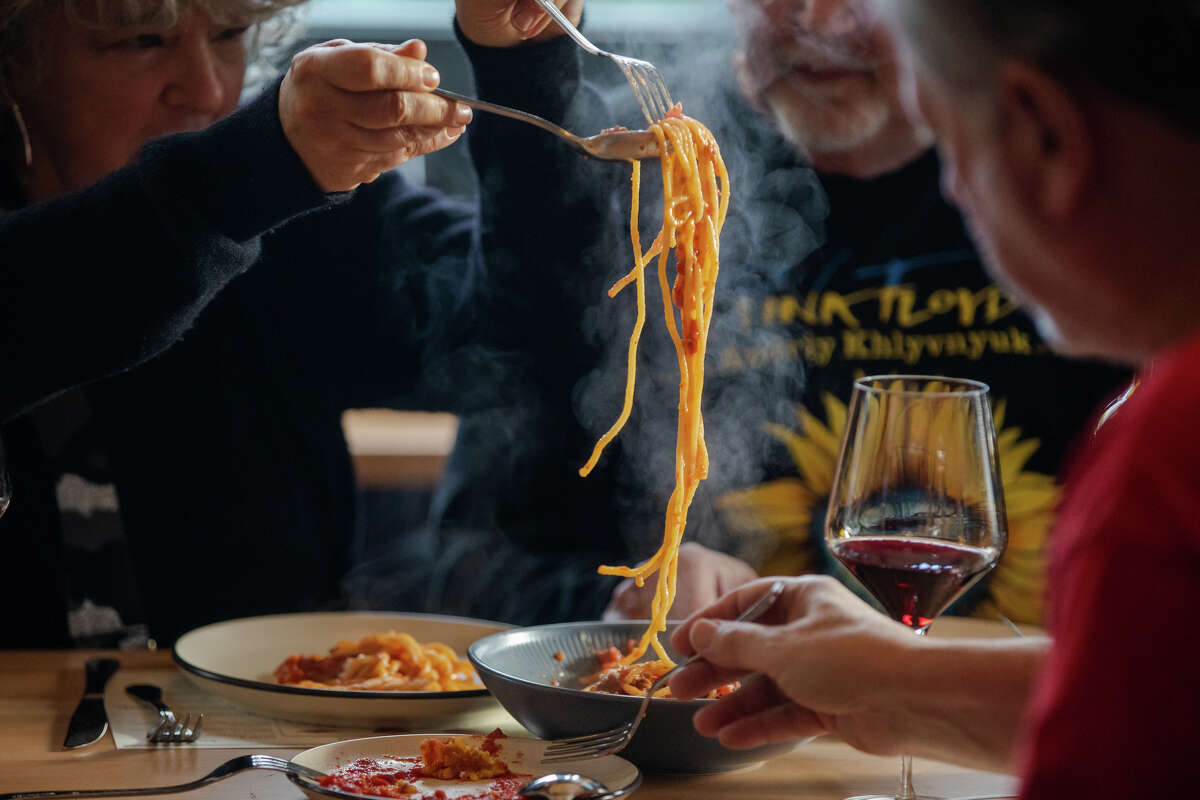 Customer And Feldman serves some pasta at her table at Pizzeria da Laura in Berkeley, Calif. on March 23, 2023.
