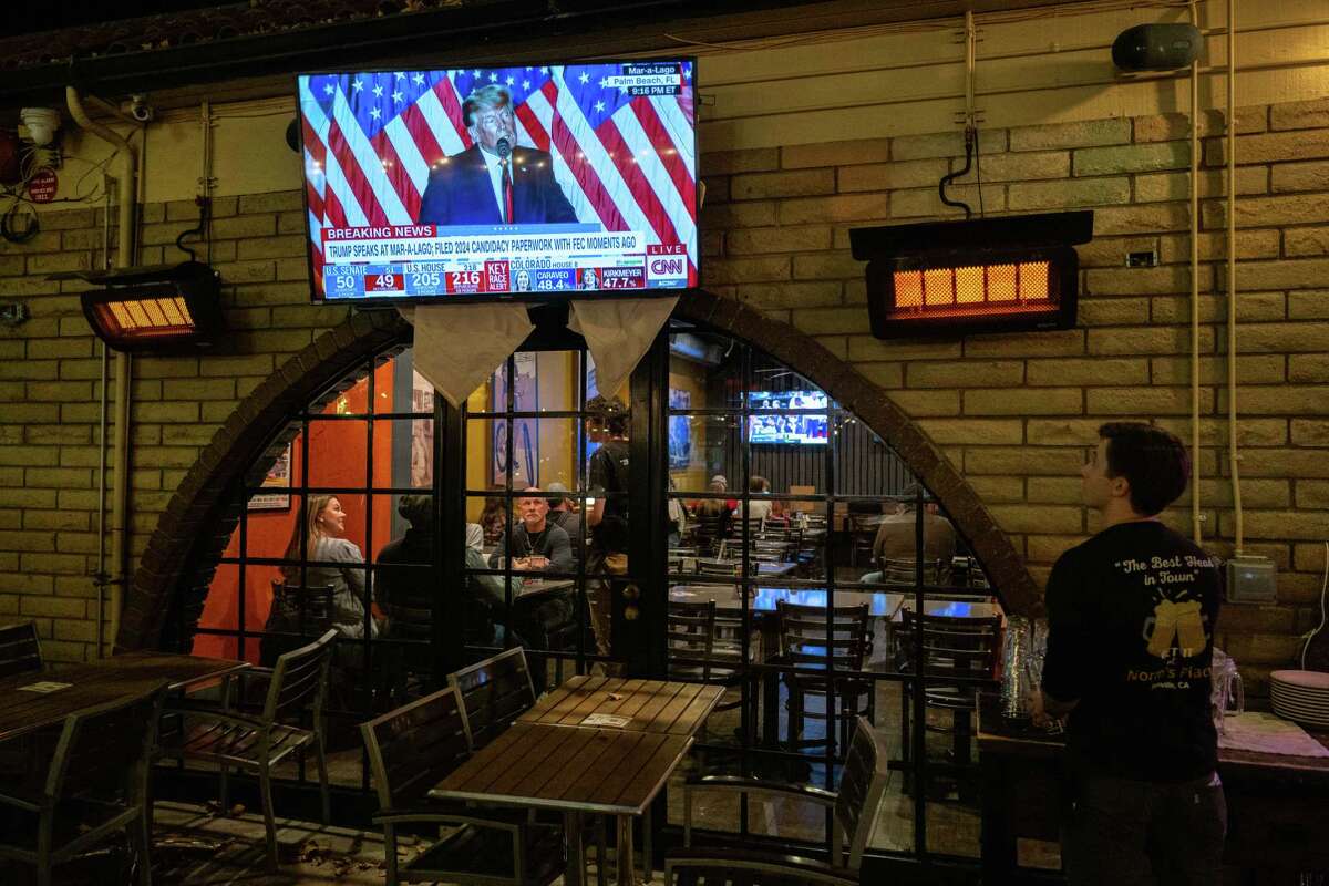 11月15日，丹维尔诺姆广场，一名餐厅员工看着唐纳德·特朗普宣布参加2024年总统竞选。