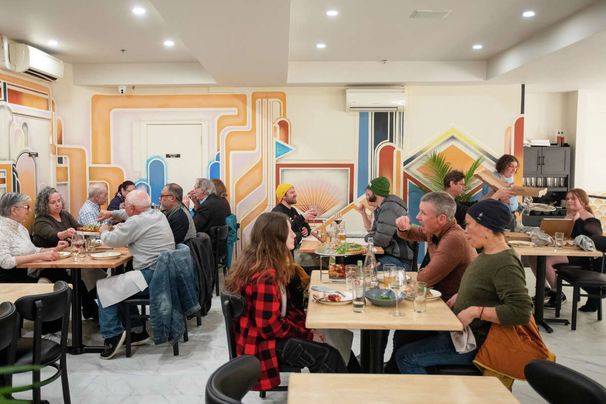Customers sit in front of a mural on the upper level of Pizzeria da Laura in Berkeley, Calif., on March 23, 2023.