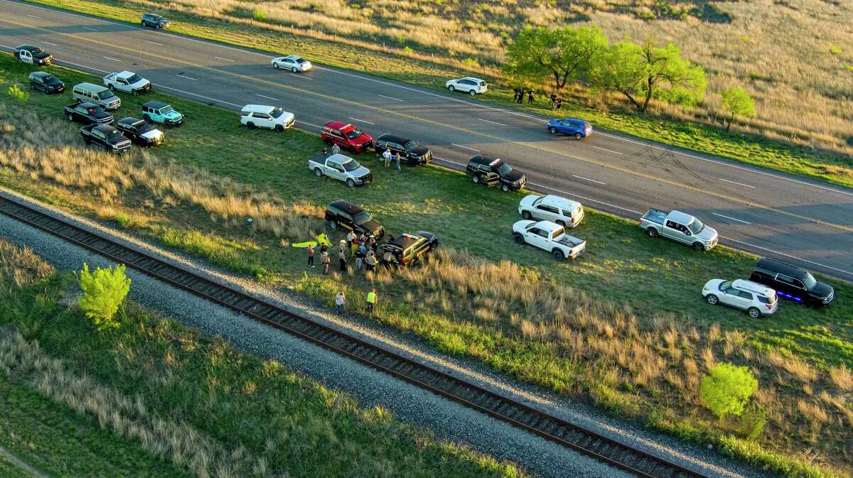 Officials investigate the scene where migrants were found trapped in a train car, Friday, March 24, 2023 in Ulvalde, Texas. Union Pacific railroad said in a statement that the people were found in two cars on the train traveling east from Eagle Pass bound for San Antonio. (William Luther/The San Antonio Express-News via AP)