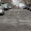 A view of uneven and cracked pavement along Dora Street in Stamford, Conn., on Saturday March 25, 2022.