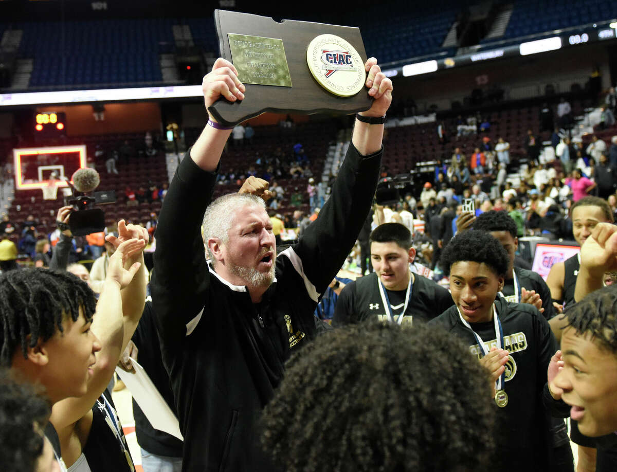 WCA Ronan Oleary holds the state champion trophy after No. 2 Waterbury Career Academy's 74-58 win over No. 1 Bloomfield in the CIAC Divison III boys basketball championship at Mohegan Sun Arena in Uncasville, Conn. Sunday, March 19, 2023.