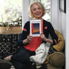 Former Broadway performer Christine Barker poses with her new memoir "Third Girl from the Left" at her home in the Riverside section of Greenwich, Conn. Monday, March 27, 2023. Barker found professional success in the longtime Broadway musical "A Chorus Line" but lost friends and family to the AIDS crisis along the way.