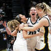 Edwardsville's Kate Martin (center) celebrates with Iowa teammates Gabbie Marshall (left) and Monika Czinano (right) after an Elite 8 victory in the NCAA Tournament against Louisville on Sunday in Seattle. Iowa 97-83. 
