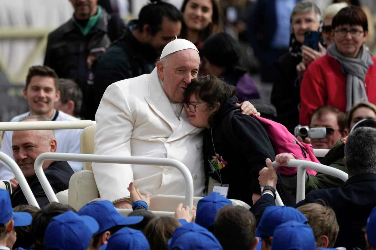 Pope Francis hugs a child at the end of his weekly general audience in St. Peter's Square, at the Vatican, Wednesday, March 29, 2023.