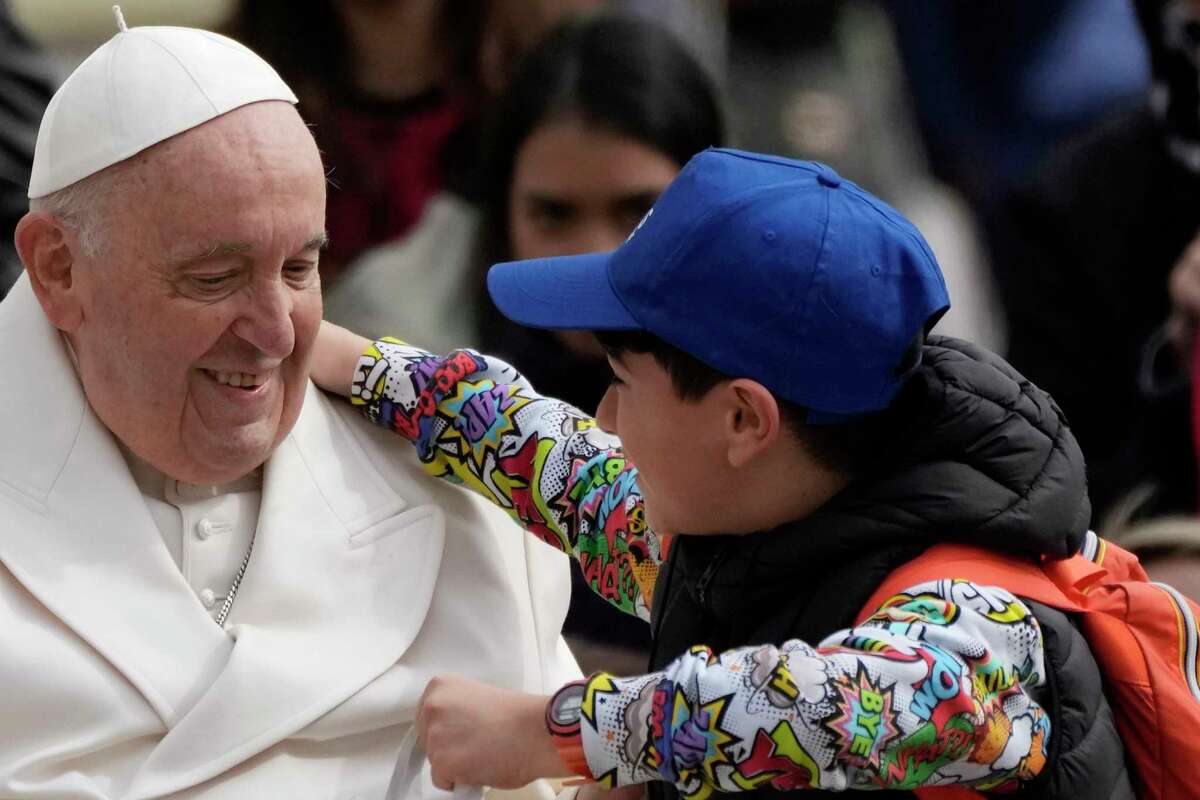 Pope Francis hugs a child at the end of his weekly general audience in St. Peter's Square, at the Vatican, Wednesday, March 29, 2023.