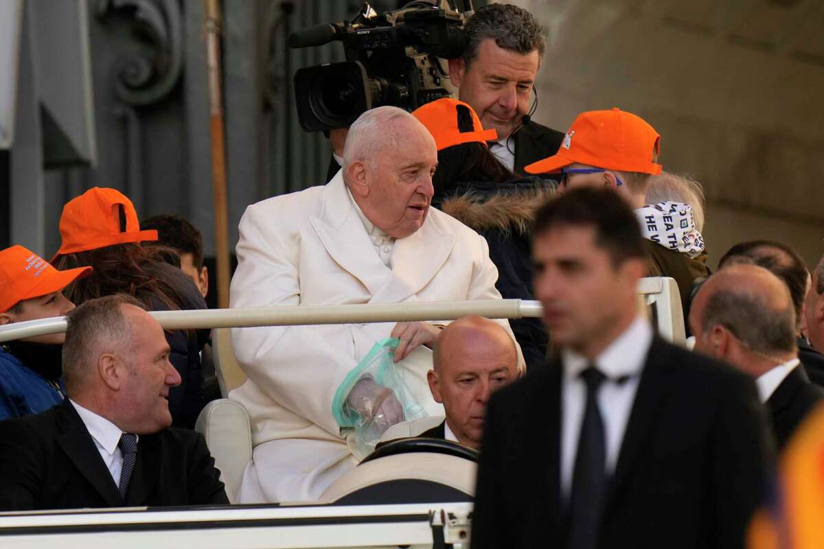 Pope Francis holds a plastic bag as he arrives for his weekly general audience in St. Peter's Square, at the Vatican, Wednesday, March 29, 2023.