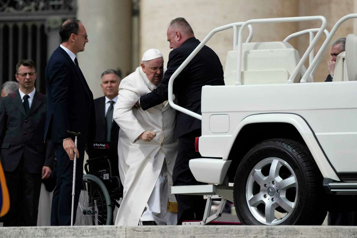 Pope Francis helped to get on his car at the end of weekly general audience in St. Peter's Square, at the Vatican, Wednesday, March 29, 2023. Pope Francis went to a Rome hospital on Wednesday for some previously scheduled tests, slipping out of the Vatican after his general audience and before the busy start of Holy Week this Sunday.