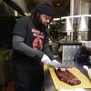 Ricky Evans, owner of Ricky D's Rib Shack, prepares an order of 1/2 slab of pork ribs at his eatery on Winchester Avenue in New Haven on March 29, 2023.