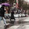 2023年3月28日，星期二，大雨中，人们打着伞穿过加利福尼亚州旧金山的瓦伦西亚街。