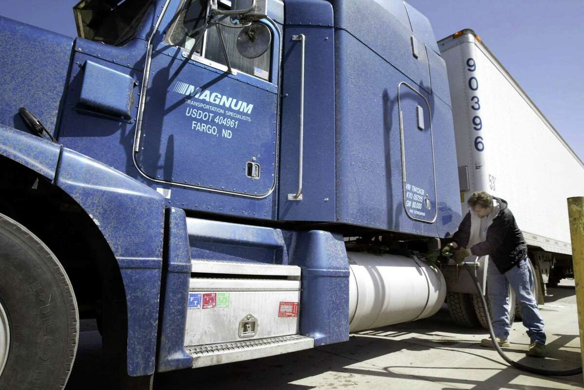 在北达科他州，一名卡车司机正在给一个150加仑的油箱加油。周五，拜登政府批准了一项豁免，允许加州为半卡车设定自己的排放标准。