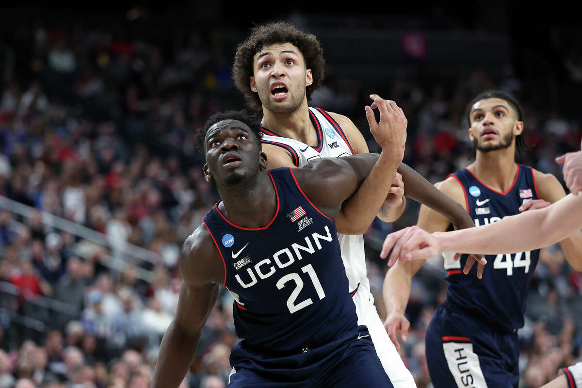 Adama Sanogo #21 of the Connecticut Huskies and Julian Strawther #0 of the Gonzaga Bulldogs compete for position during a free throw during the first half in the Elite Eight round of the NCAA Men's Basketball Tournament at T-Mobile Arena on March 25, 2023 in Las Vegas, Nevada.