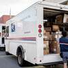 6月8日，在美国旧金山，一名邮政工人将亚马逊的箱子装上卡车。