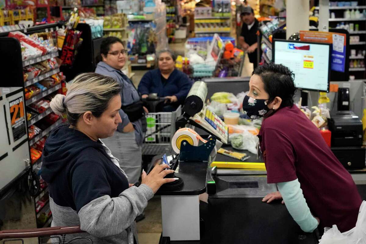 Soila Arredondo checks out customers at H-E-B’s Mi Tienda grocery store in the 3800 block of Little York on Thursday, April 6, 2023, in Houston.