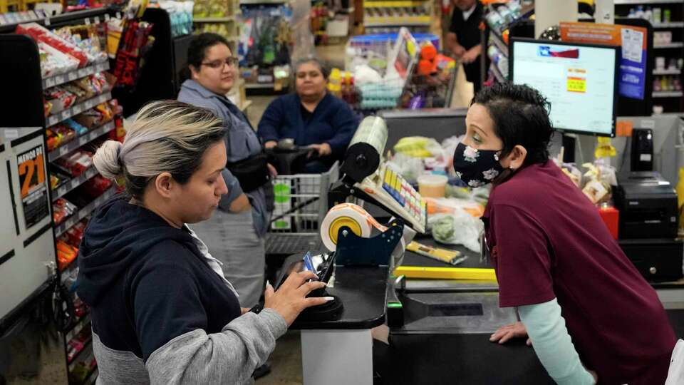 Soila Arredondo checks out customers at H-E-B's Mi Tienda grocery store in the 3800 block of Little York on Thursday, April 6, 2023 in Houston.