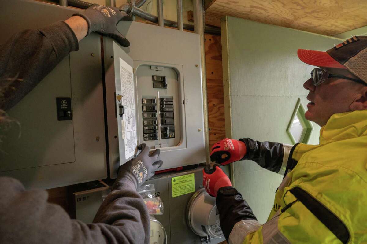 Isaac Bonnell (left) and Tom Hicks, solar technicians with Luminalt, work on decommissioning the solar panels in a home in San Francisco on Friday. Many homeowners are hurrying to swap out old panels for new ones before California reduces incentives for rooftop panels next Friday.