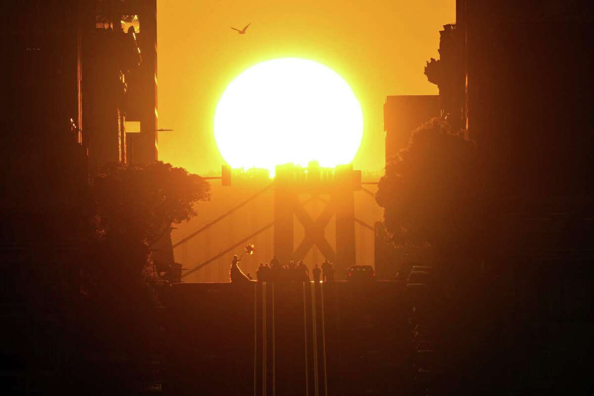 周日，太阳在旧金山加利福尼亚街的海湾大桥上升起，这是一年两次的现象，被称为加利福尼亚恒日。