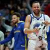 Golden State Warriors guard Stephen Curry (30) reacts after a basket by forward Jonathan Kuminga during the second half of an NBA basketball game in Portland, Ore., Sunday, April 9, 2023. (AP Photo/Craig Mitchelldyer)