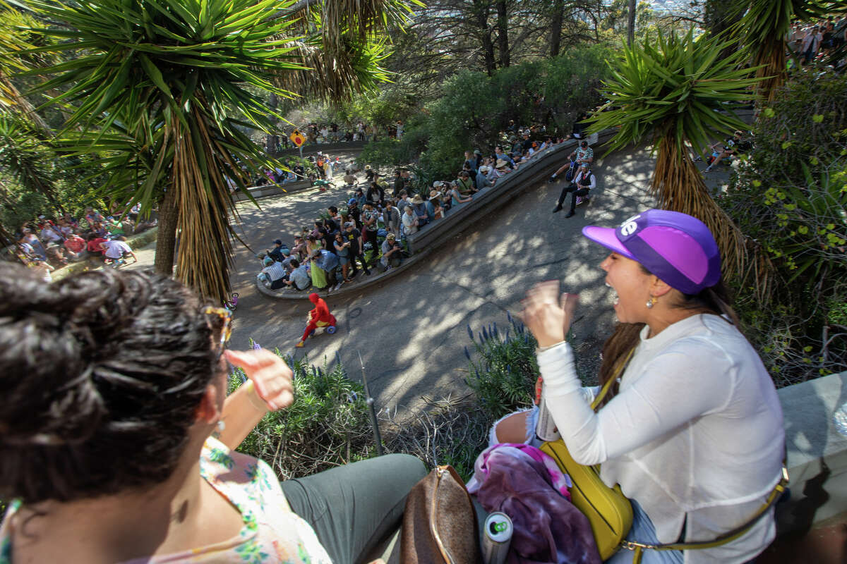 Spectators line the road and watch the racers during the Bring Your Own Big Wheels race event down Vermont Street in San Francisco on April 9, 2023.