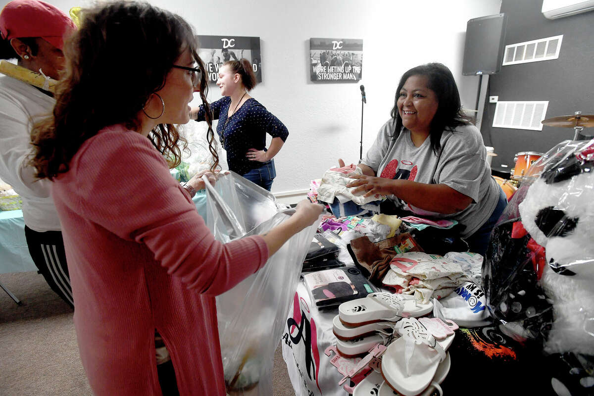 Thira Simon hands off items to volunteer Marissa Asevedo as she assists Deja Hudson in gathering baby items during the 2nd Annual Orange County Community Baby Shower at Destiny Church in Orange. Photo made Saturday, April 8, 2023 Kim Brent/Beaumont Enterprise