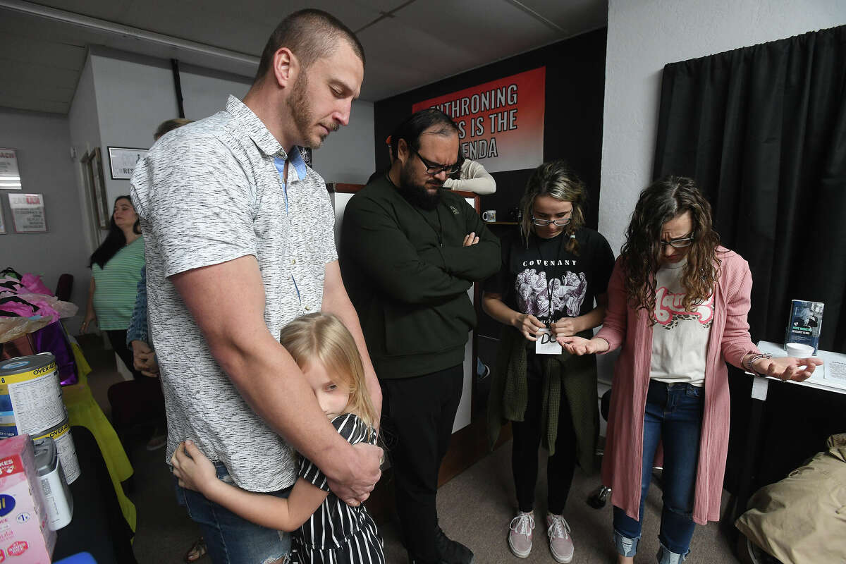 Luke Eggers hugs daughter Scarlett as they and other church members pray before the 2nd Annual Orange County Community Baby Shower at Destiny Church in Orange. Photo made Saturday, April 8, 2023 Kim Brent/Beaumont Enterprise