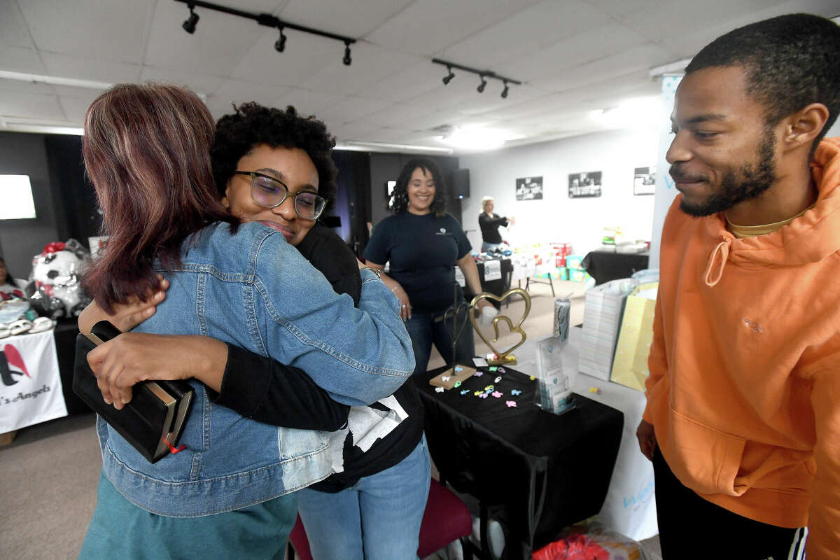 Apryl Young hugs Wells of Agape founder Donna Wells as her boyfriend Keith Vallair looks on during the 2nd Annual Orange County Community Baby Shower at Destiny Church in Orange. Photo made Saturday, April 8, 2023 Kim Brent/Beaumont Enterprise